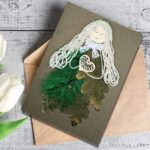 A beautiful National Women's Day card, depicting a girl with a heart, adorned with feathers and dry leaves.